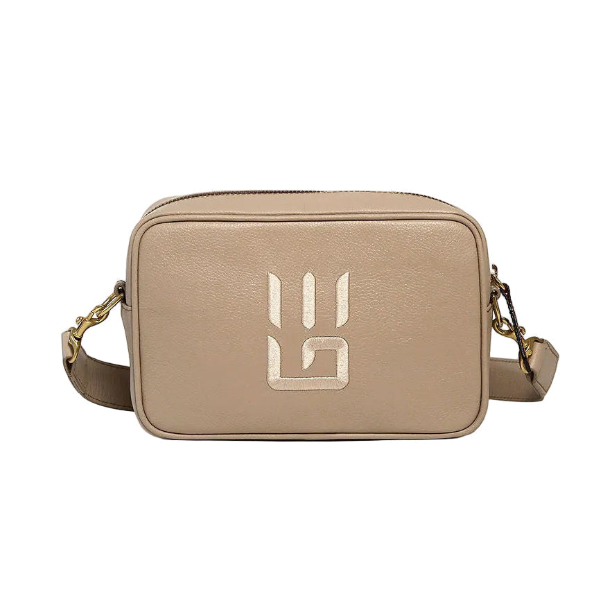 A beige leather crossbody camera bag with a gold geometric logo on the front, displayed on a clean white background.